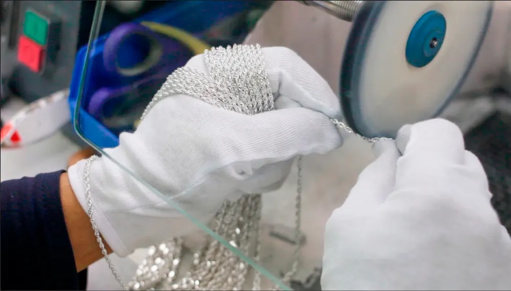Joyero puliendo piezas de Plata con guantes blancos en New Fashion Peru